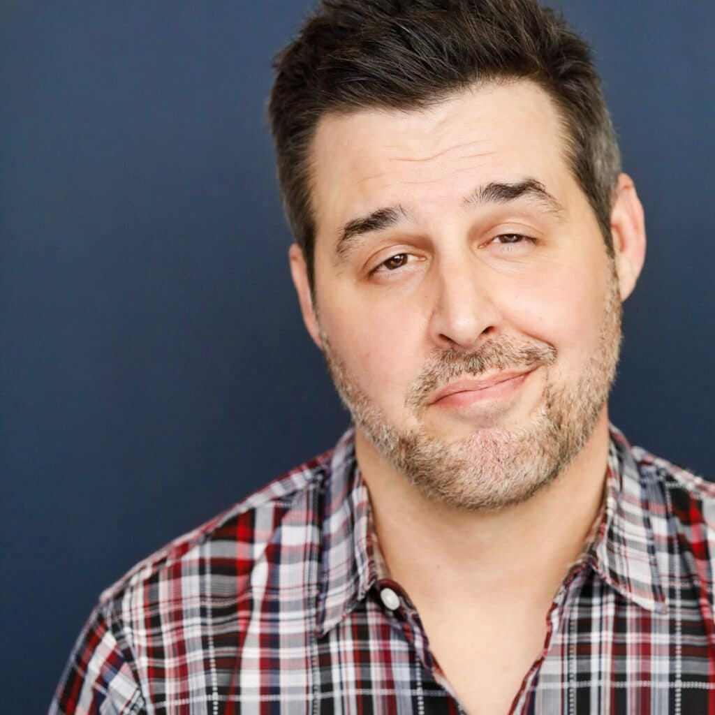 a man with a beard and mustache wearing a plaid shirt